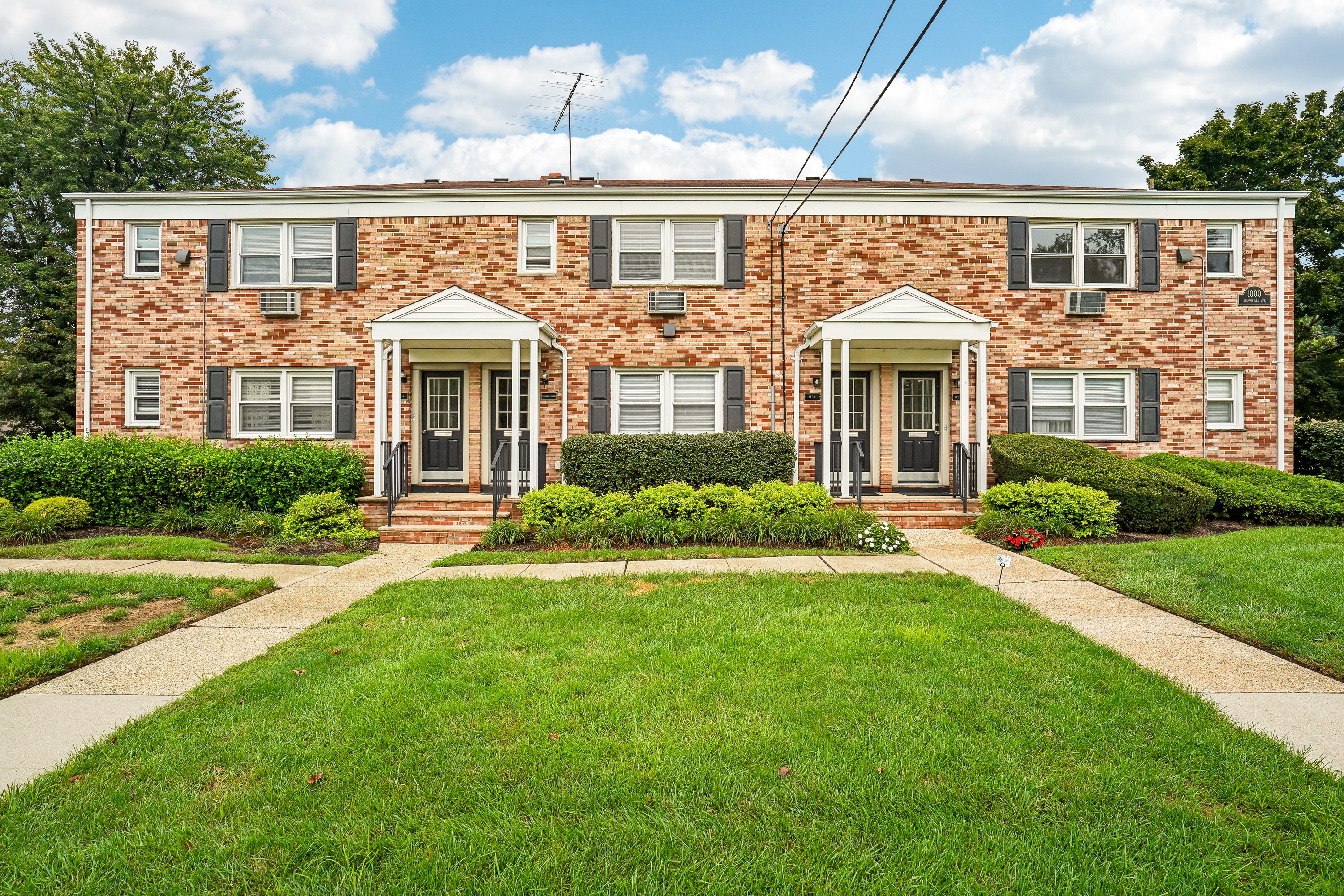 A brick house with a green lawn in front.